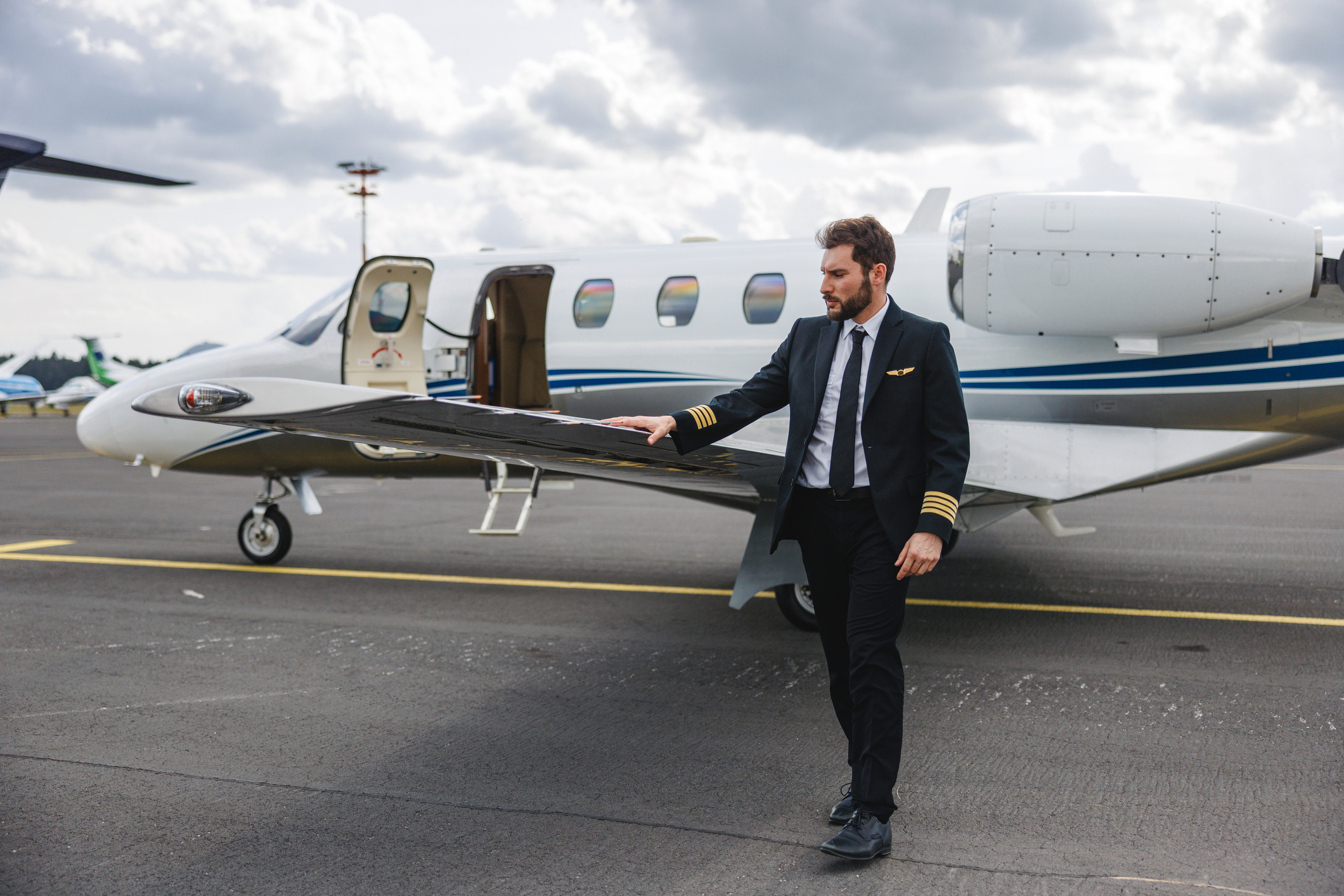 Confident Pilot Checking Private Jet Before Flight Confident Pilot Checking Private Jet Before Flight